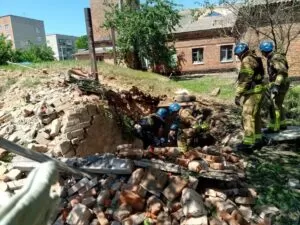 Пожежники вибираються із залишків укриття після артобстрілу Білопілля